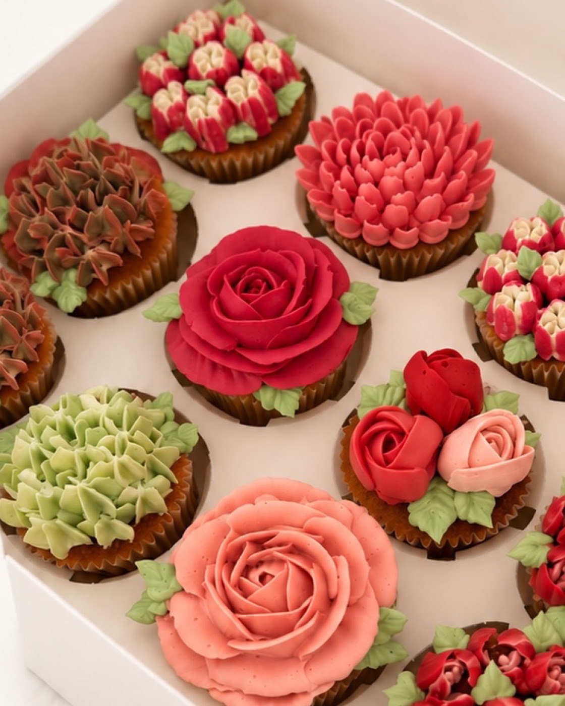 Cupcakes mit Rosen und Pfingstrosen aus Buttercreme in einer Box